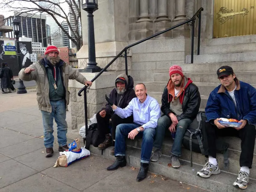 ARCM Roofing team member sharing a Christmas lunch with neighbors on church steps in downtown Denver