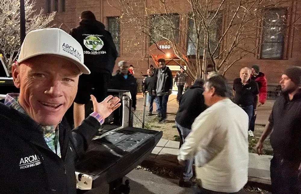 ARCM Roofing crew serving a hot meal to neighbors experiencing homelessness in Denver