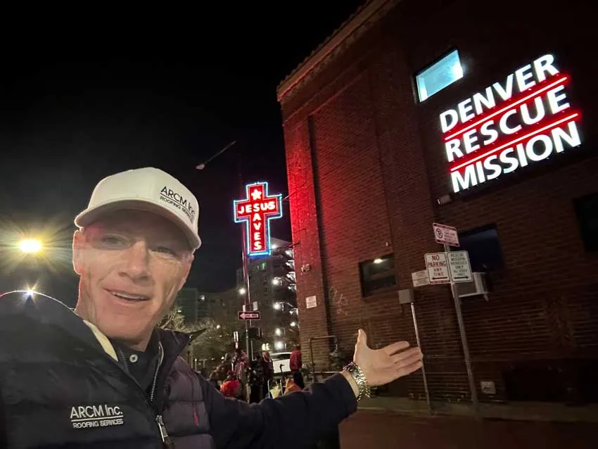 ARCM Roofing team member outside the Denver Rescue Mission at night