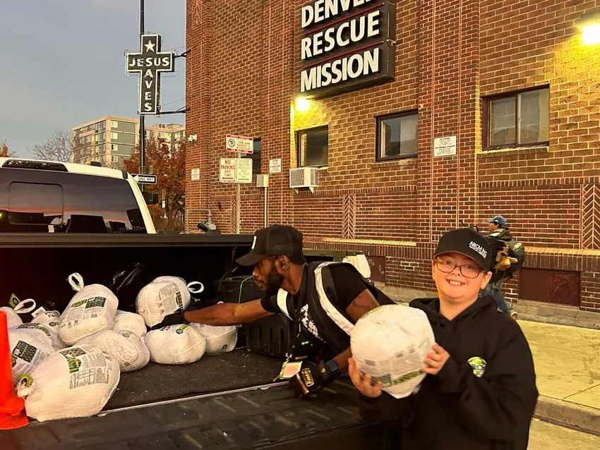 ARCM Roofing volunteers handing out turkeys from a truck outside the Denver Rescue Mission